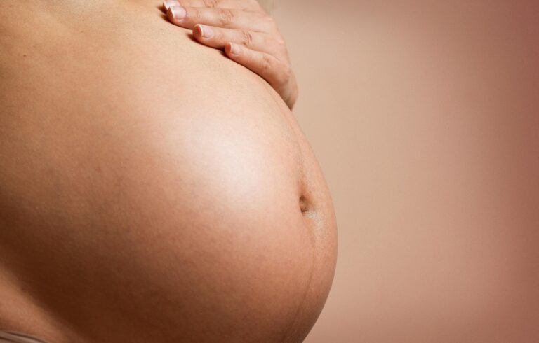 Grávida com a mão na barriga. Obesidade durante a gravidez