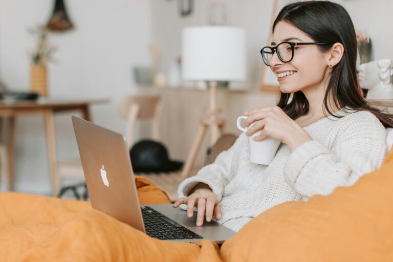 Psicóloga atendendo online com notebook em mãos e um café