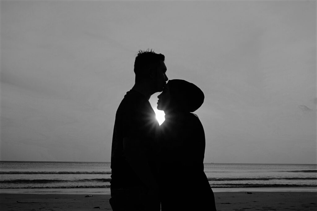 Casal abraçado em frente ao mar.