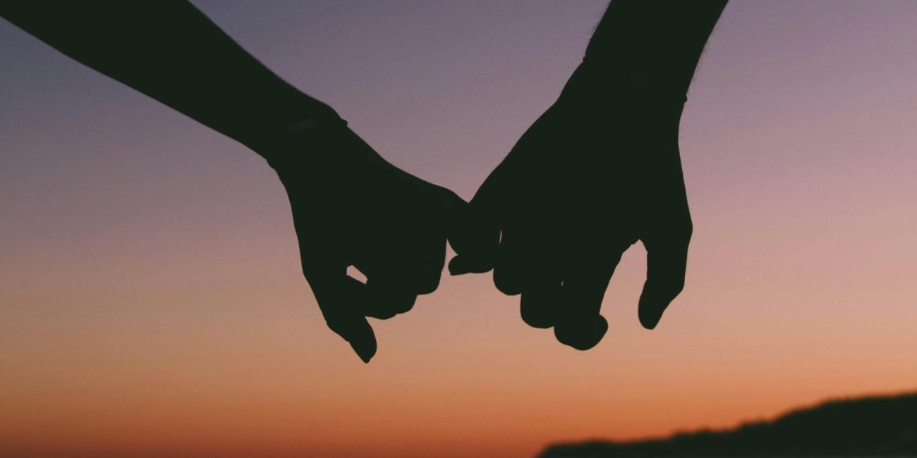 Casal de mãos dadas com pôr-do-sol ao fundo. Lipedema-casal