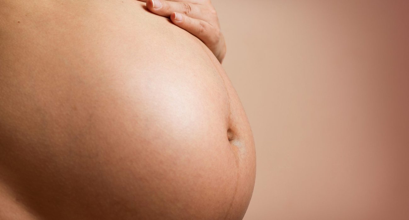 Grávida com a mão na barriga. Obesidade durante a gravidez