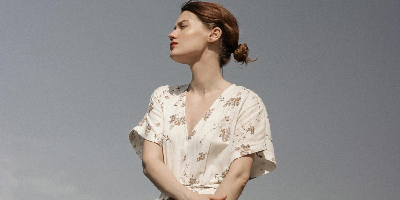 Mulher de vestido olhando para o horizonte. Pensando na terapia