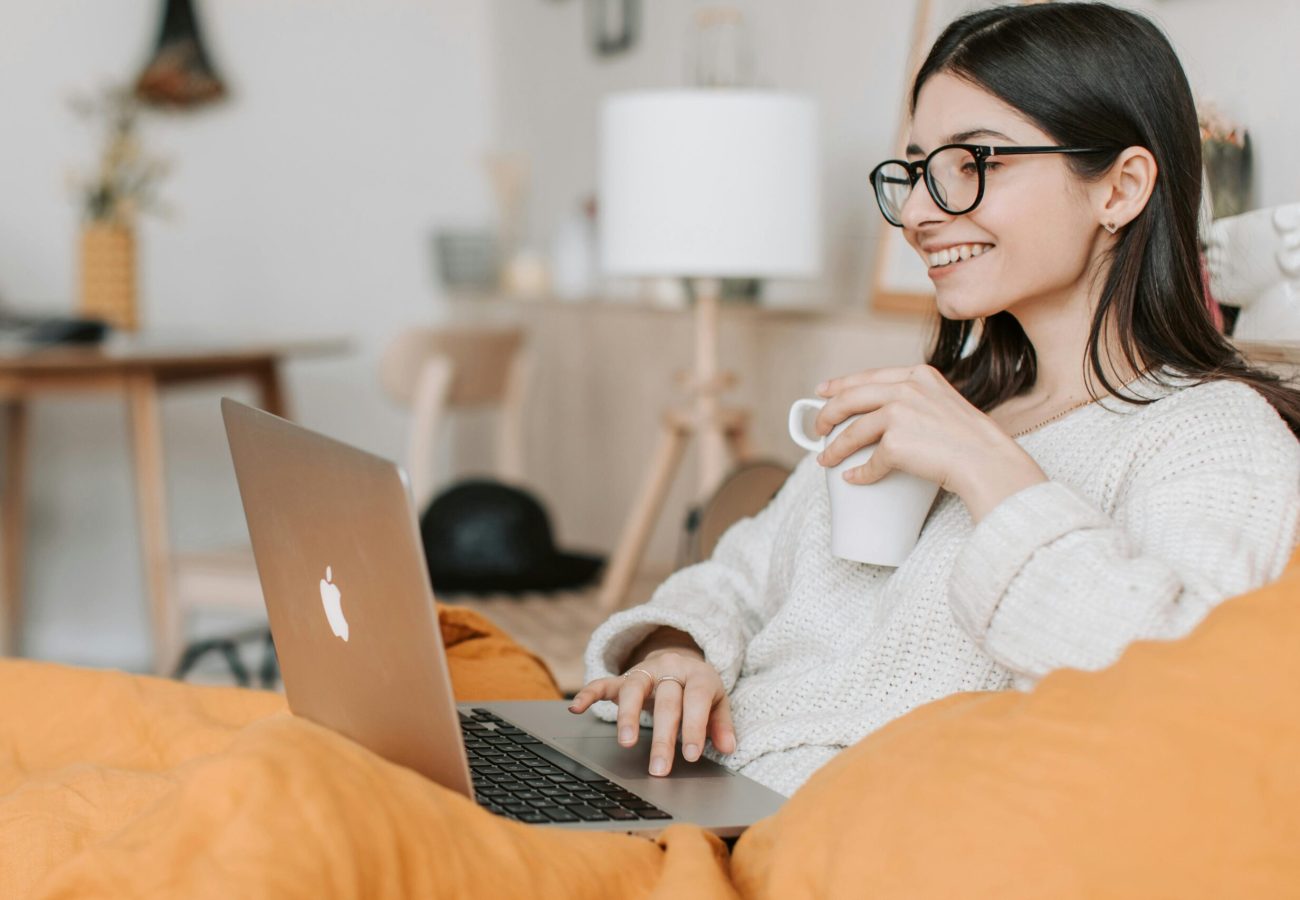 Psicóloga atendendo online com notebook em mãos e um café